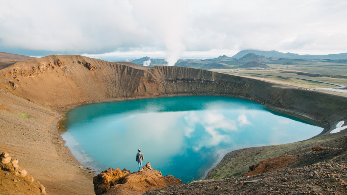 back view of man looking at majestic volcanic lake in iceland, krafla, lake viti