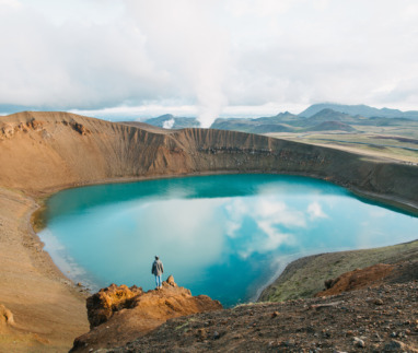 back view of man looking at majestic volcanic lake in iceland, krafla, lake viti