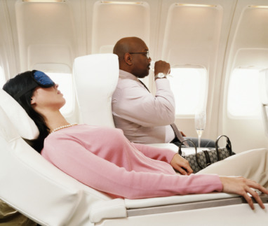 Vrouwelijke passagier ligt in vliegtuigstoel achterover te slapen