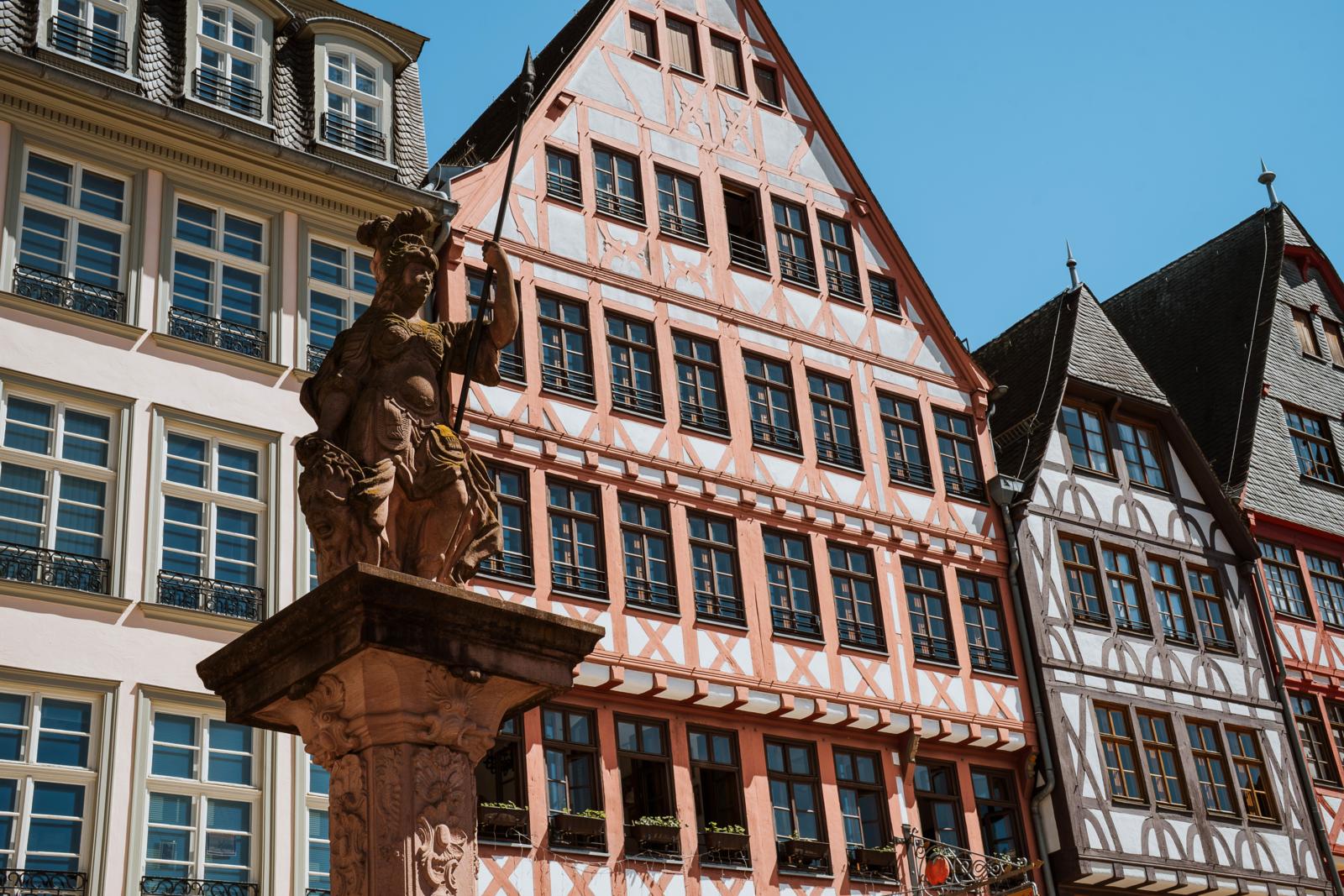 Vakwerkhuizen en standbeeld op het Römerbergplein in Frankfurt.