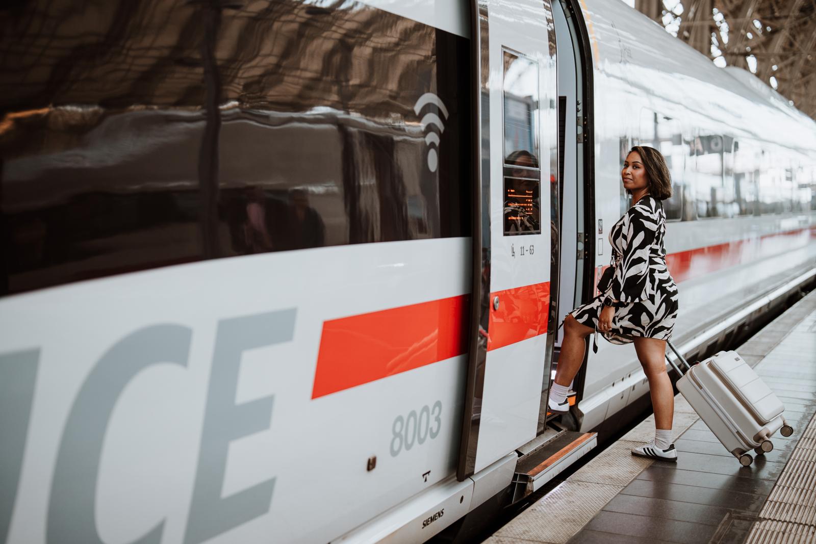Reiziger stapt met koffer uit een ICE-trein op station Frankfurt.