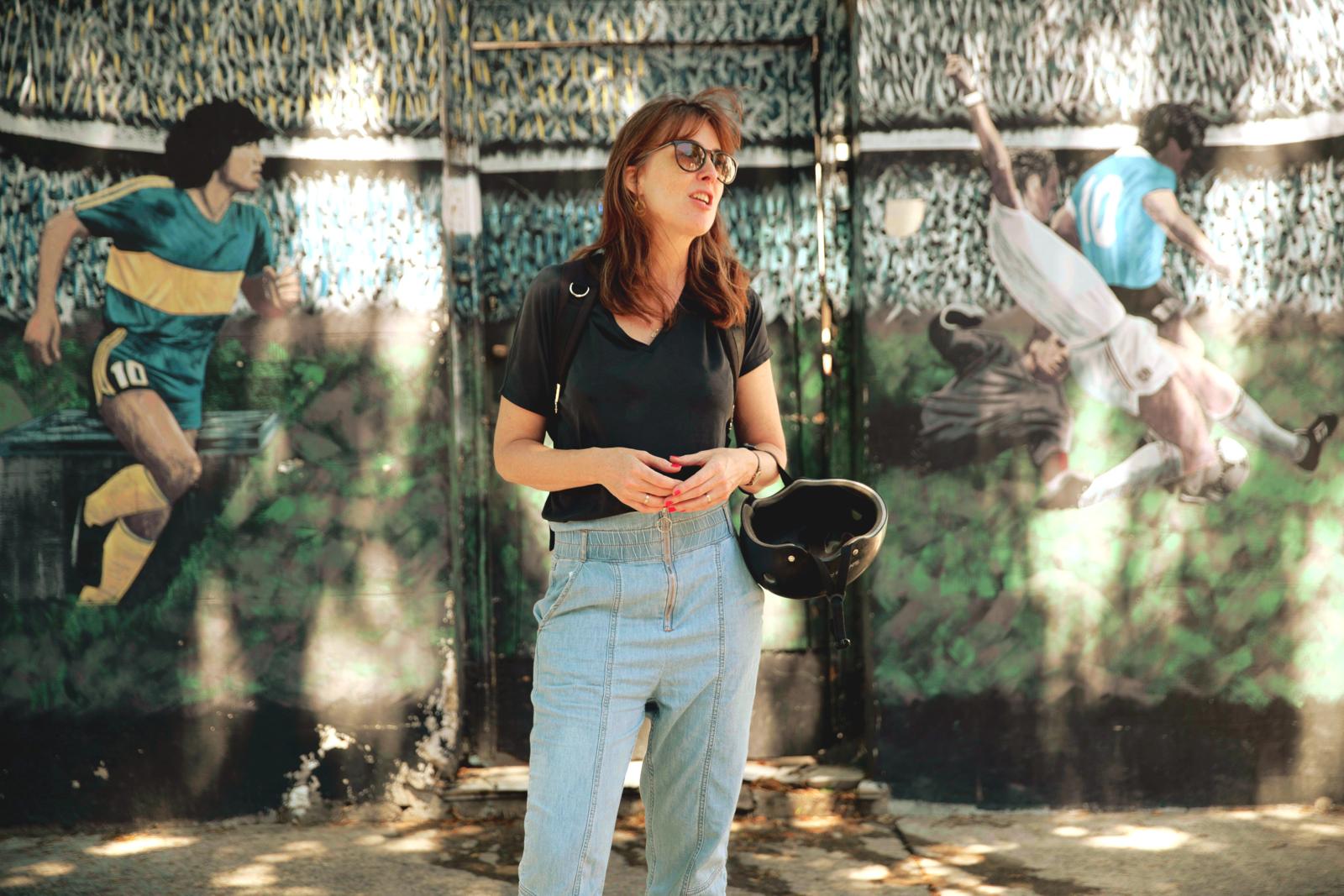 Reiziger voor muurschildering met iconische voetbalscènes in Buenos Aires.