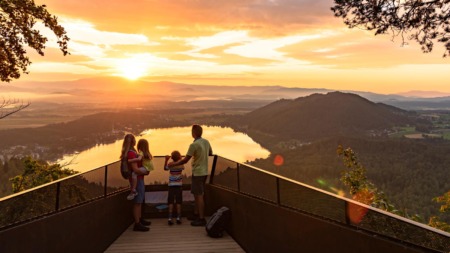Gezin kijkt uit over de Klopeiner See in Karinthië, Oostenrijk tijdens zonsondergang