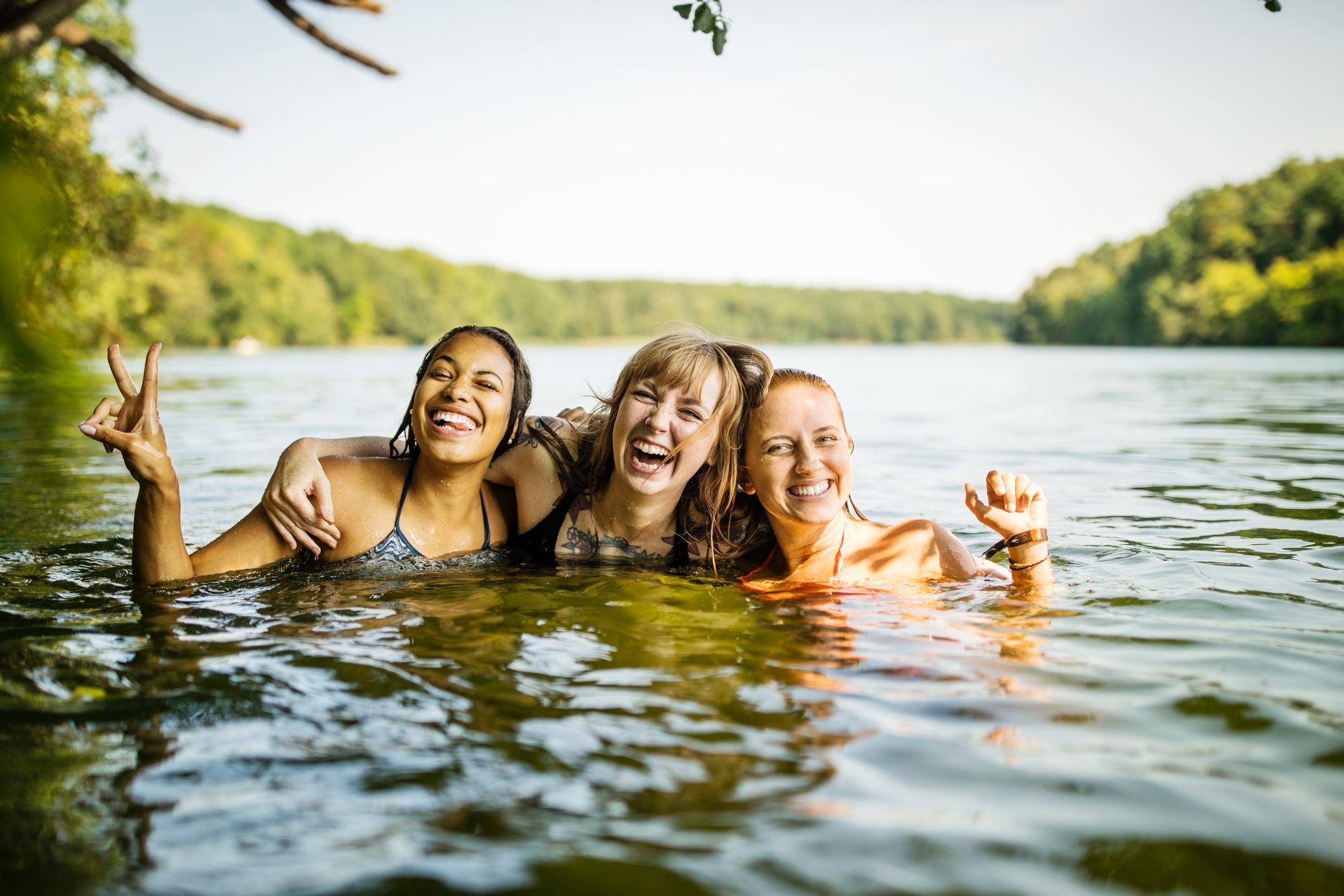 Drie vriendinnen zwemmen vrolijk samen in een meer in Duitsland in de zomer