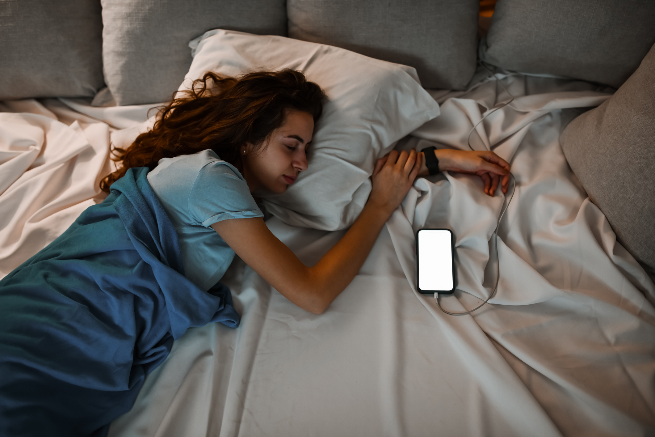 Vrouw gebruikt haar telefoon voor white noise geluiden om beter te kunnen slapen tijdens haar reis 