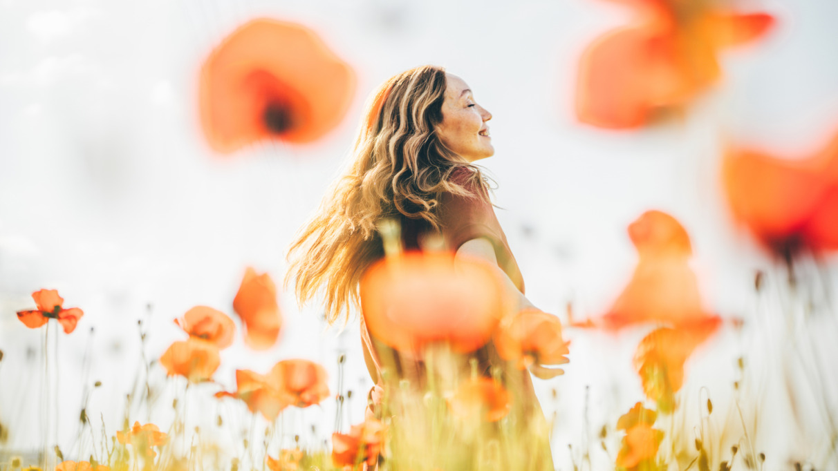 Vrouw danst door een veld vol klaprozen