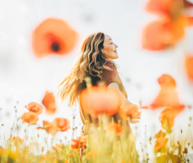 Vrouw danst door een veld vol klaprozen