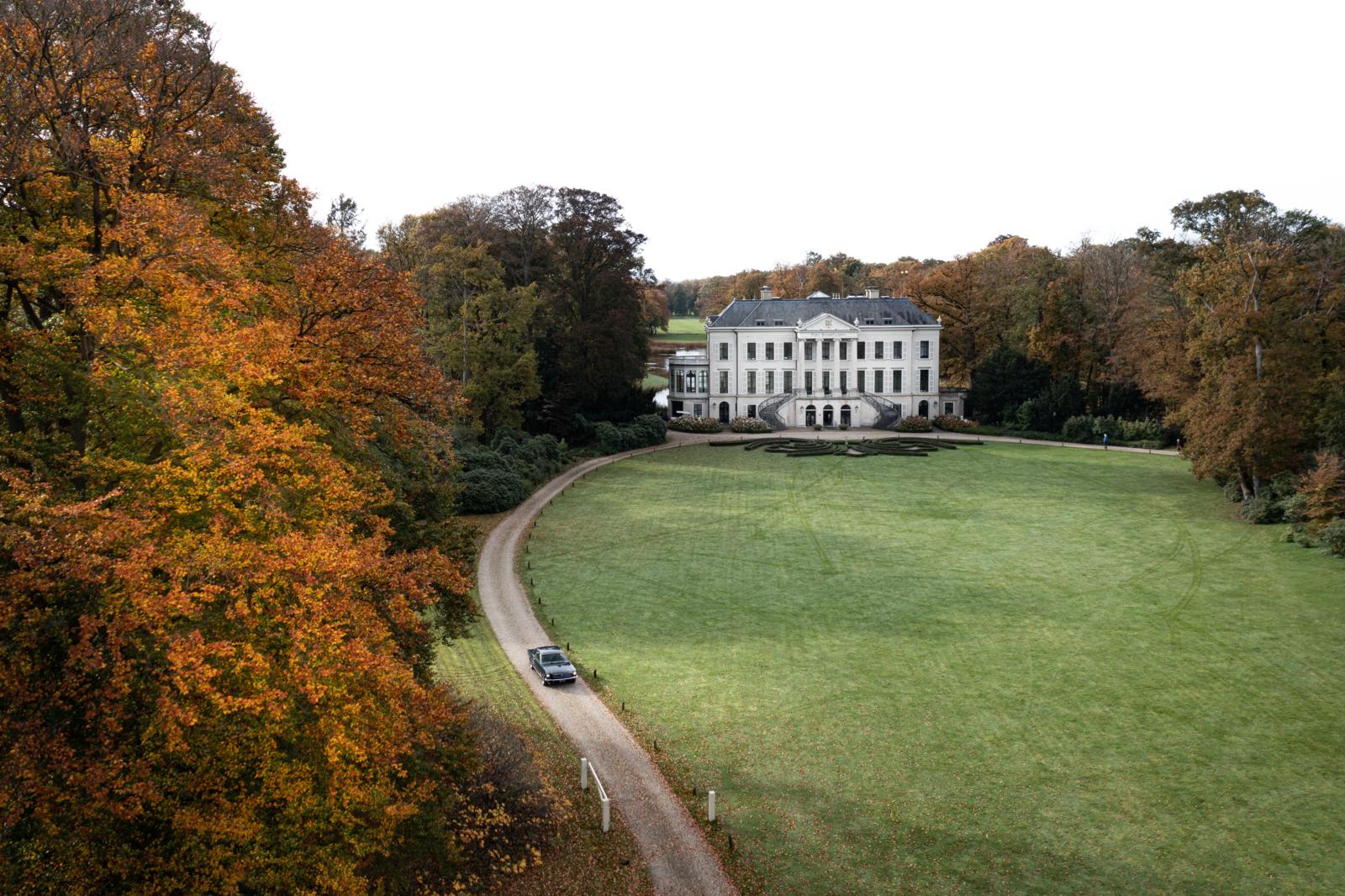 Landhuis op de Utrechtse Heuvelrug omringd door herfstbos en gazon.