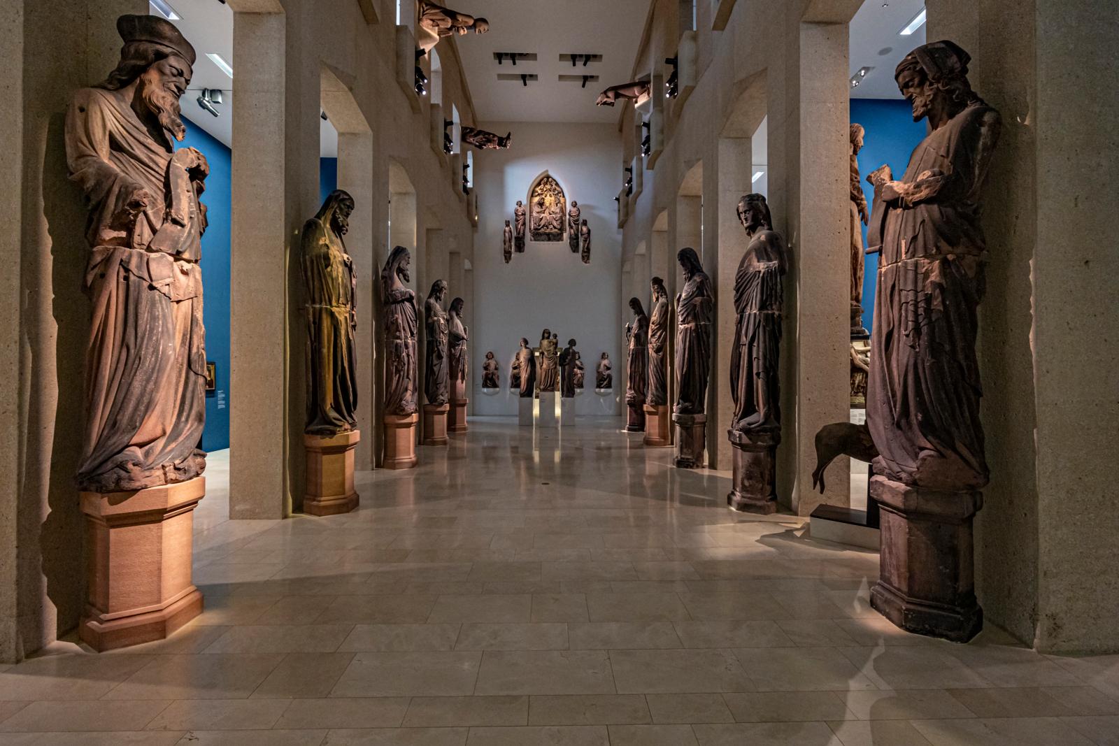 Interieur van het Augustinermuseum in Freiburg met gotische beelden en religieuze sculpturen.