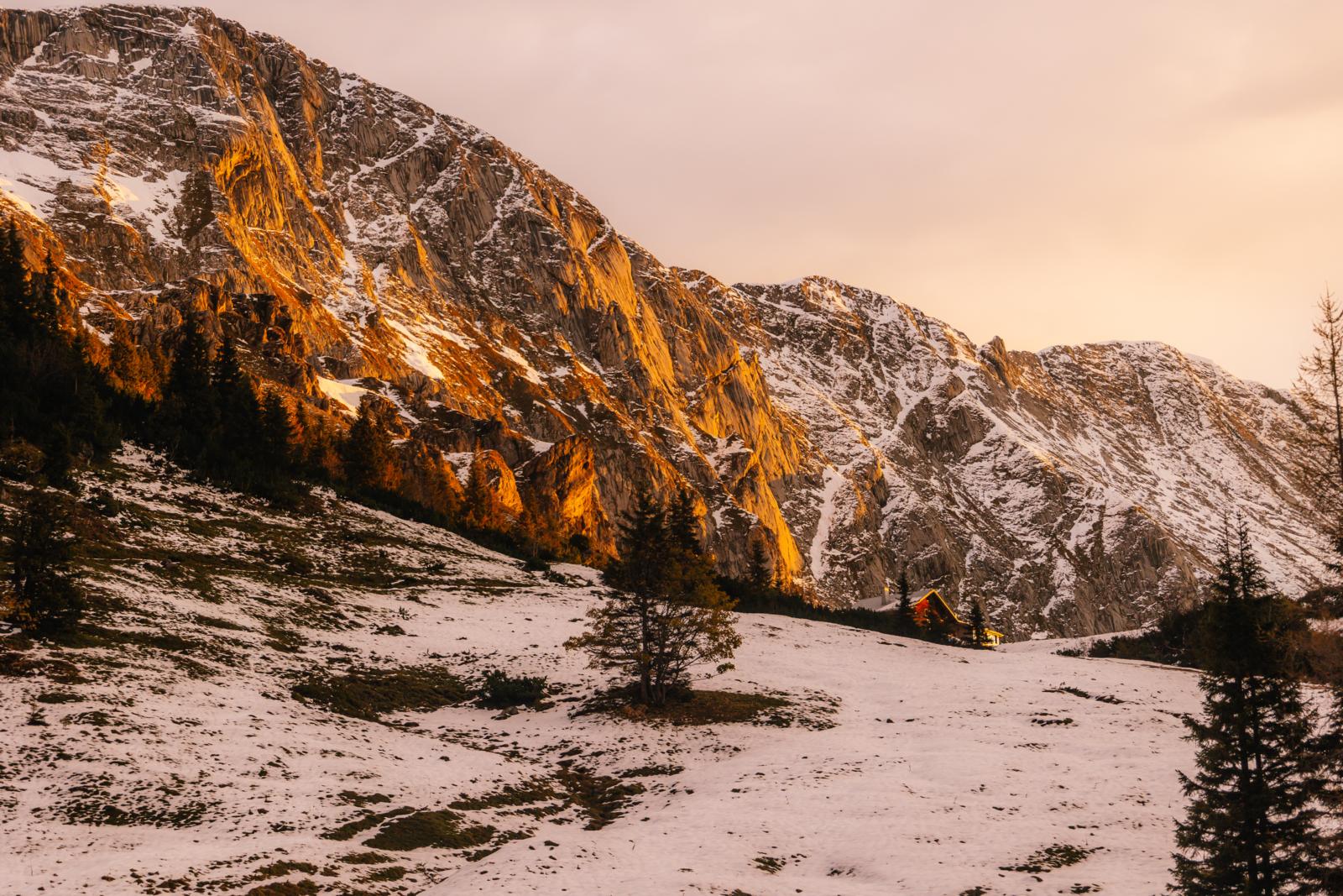 Berghut op een besneeuwde helling in Nationaal Park Berchtesgaden bij avondlicht