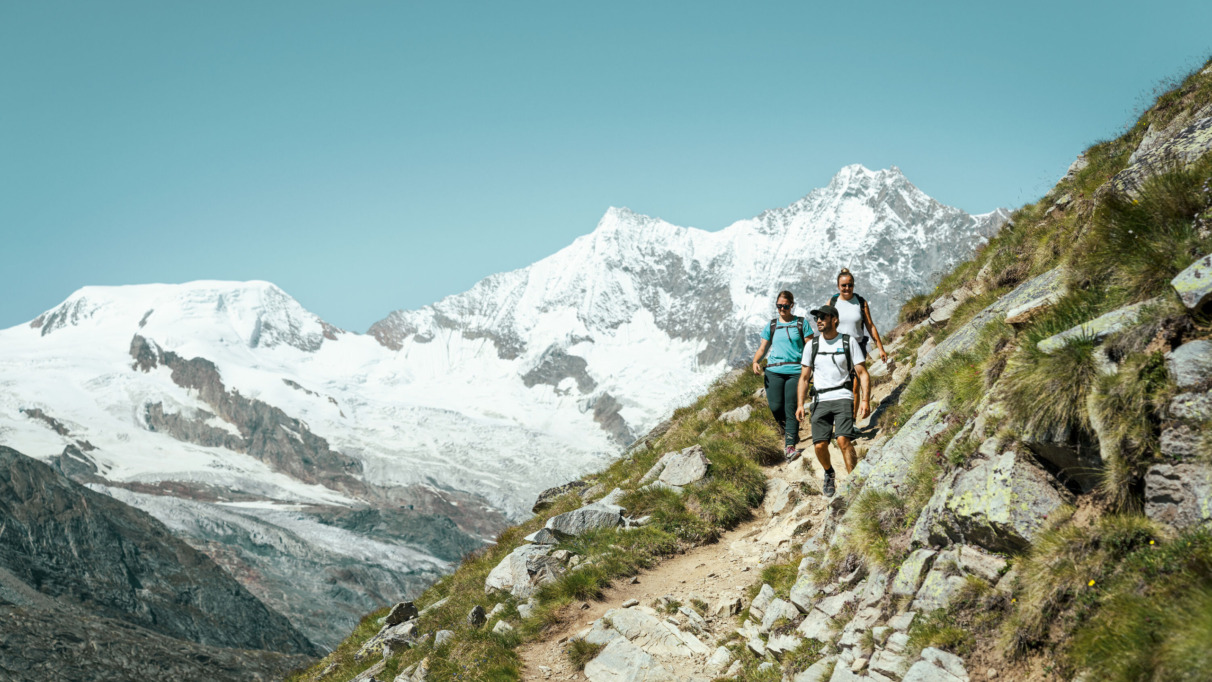 Drie hikers in de bergen van Saasfee