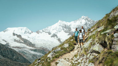 Drie hikers in de bergen van Saasfee