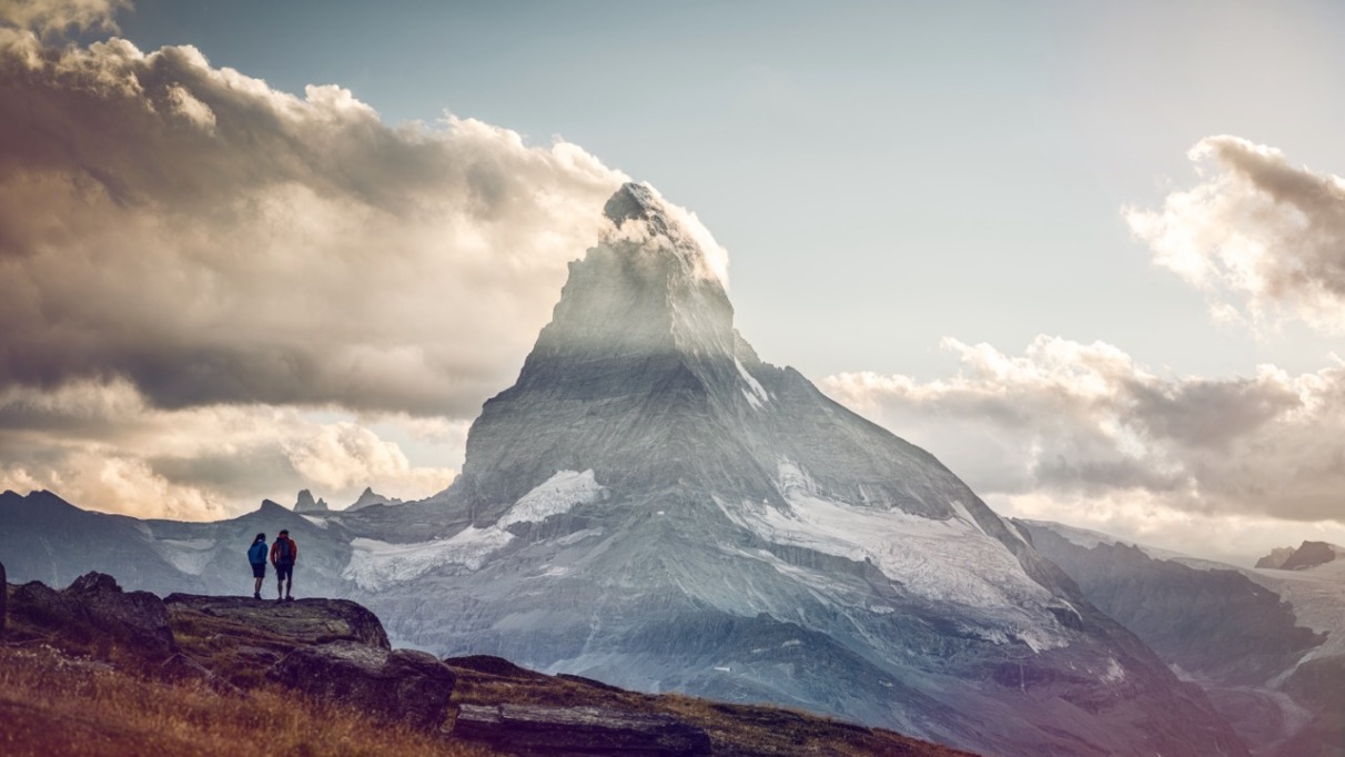 Twee hikers kijken uit op de Matterhorn in Wallis, Zwitserland