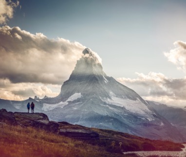 Twee hikers kijken uit op de Matterhorn in Wallis, Zwitserland
