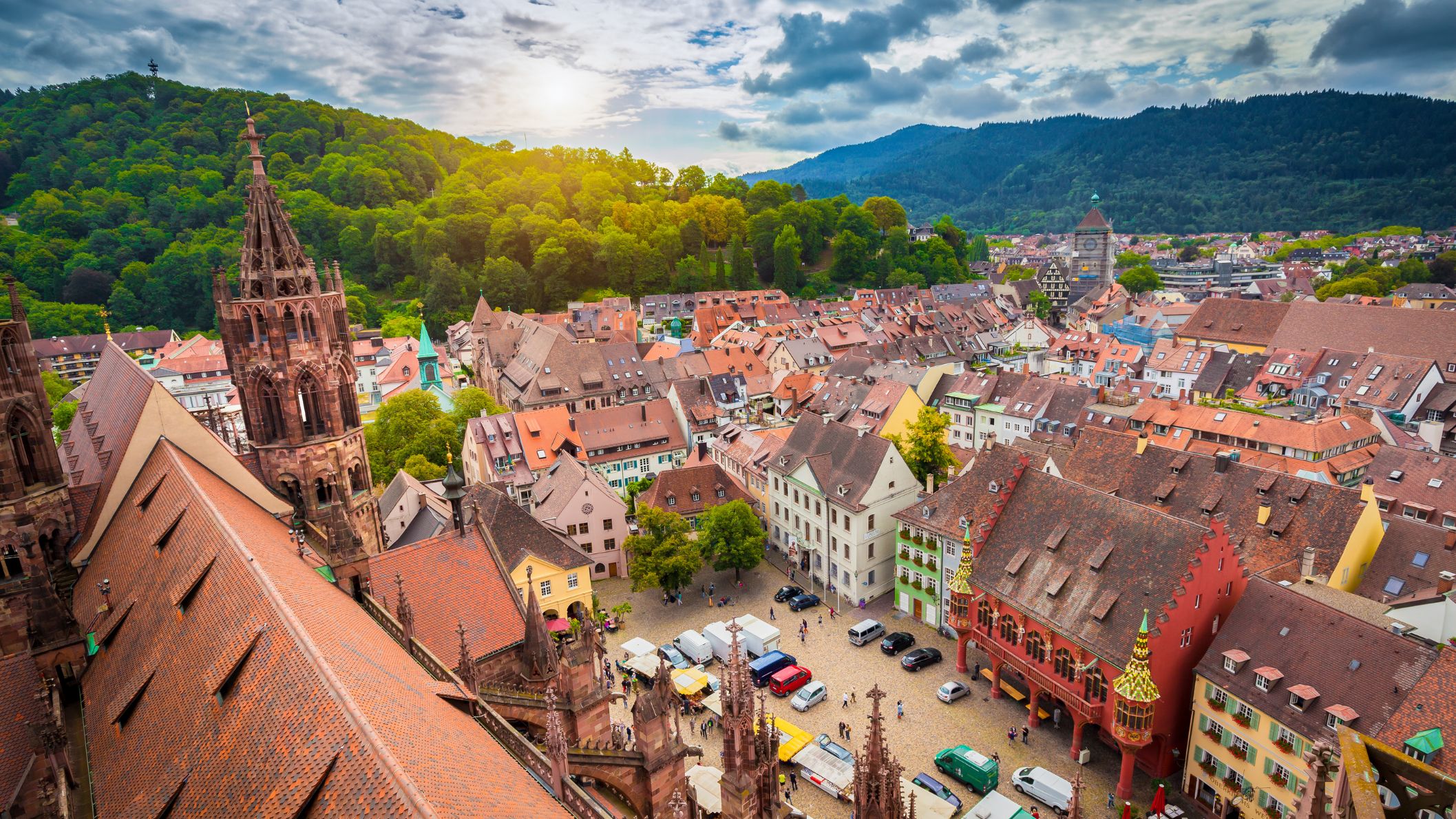 Historisch centrum van Freiburg met Münster, kleurrijke huizen en Zwarte Woud op de achtergrond.