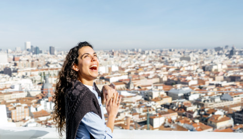 Vrouw staat te lachen boven de skyline van Madrid in Spanje