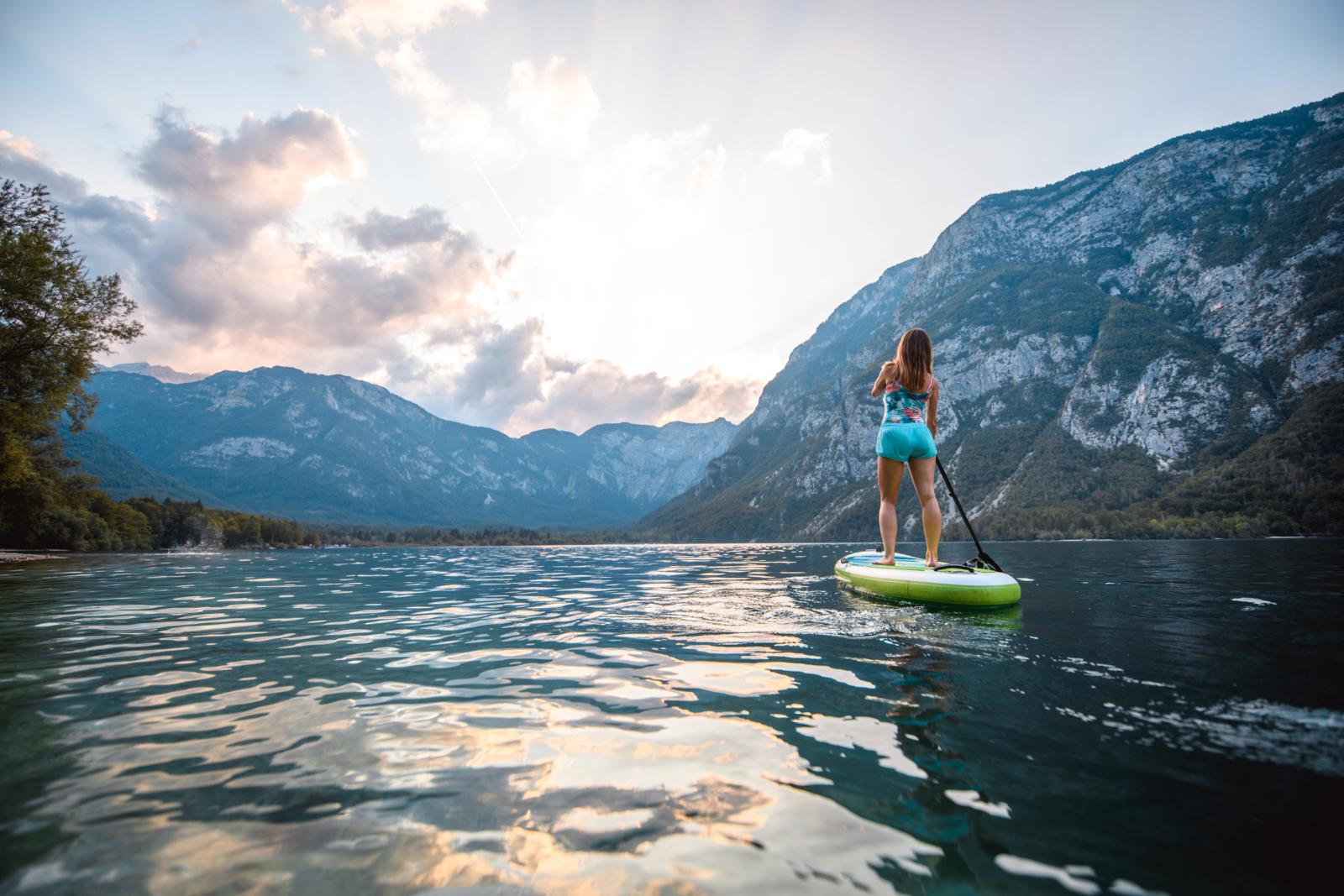 Stand-up paddleboarder op het meer van Bohinj in de Julische Alpen, Slovenië.