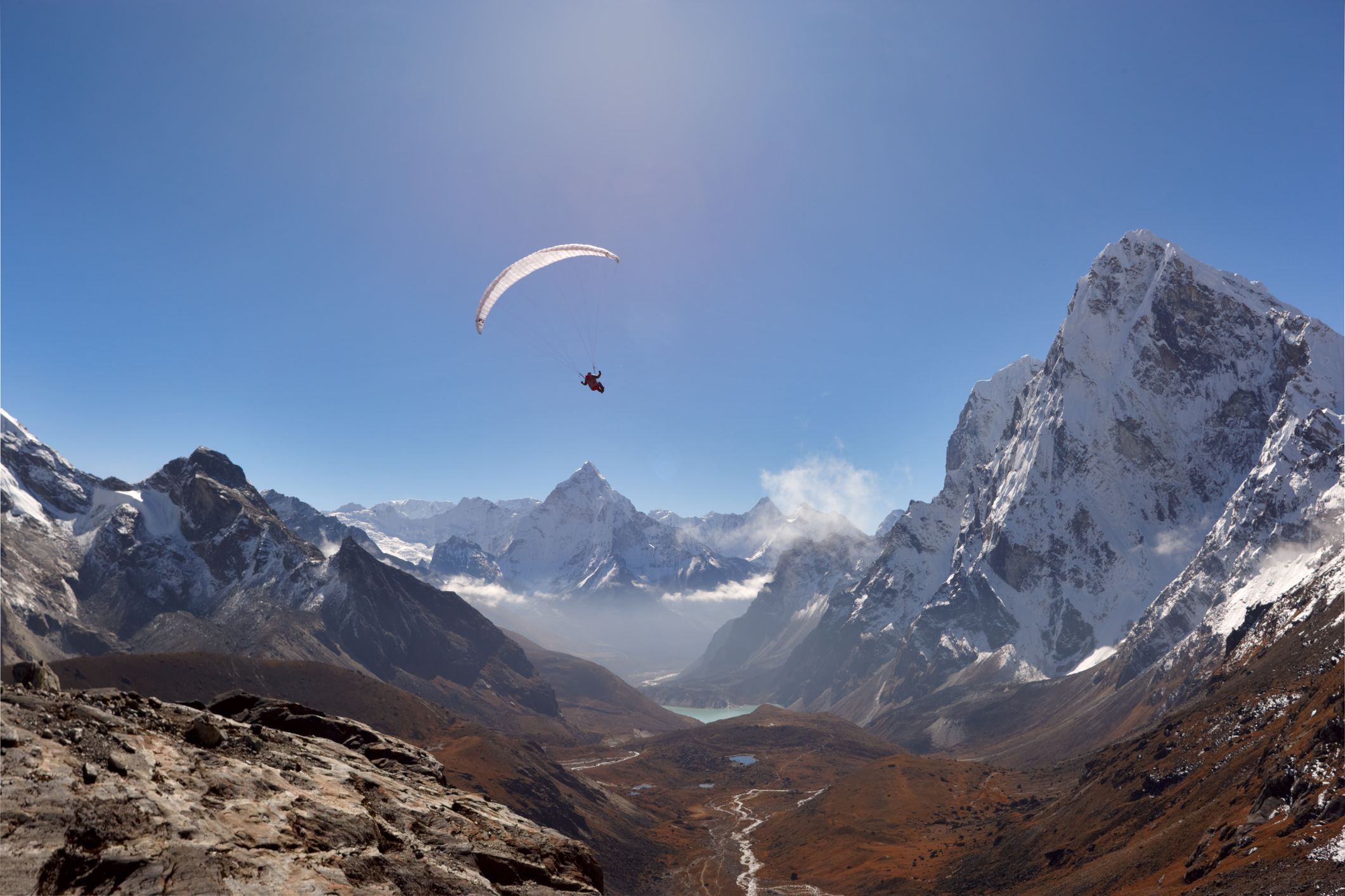 Paraglider zweeft boven de besneeuwde toppen van het Annapurna-massief bij Pokhara in Nepal