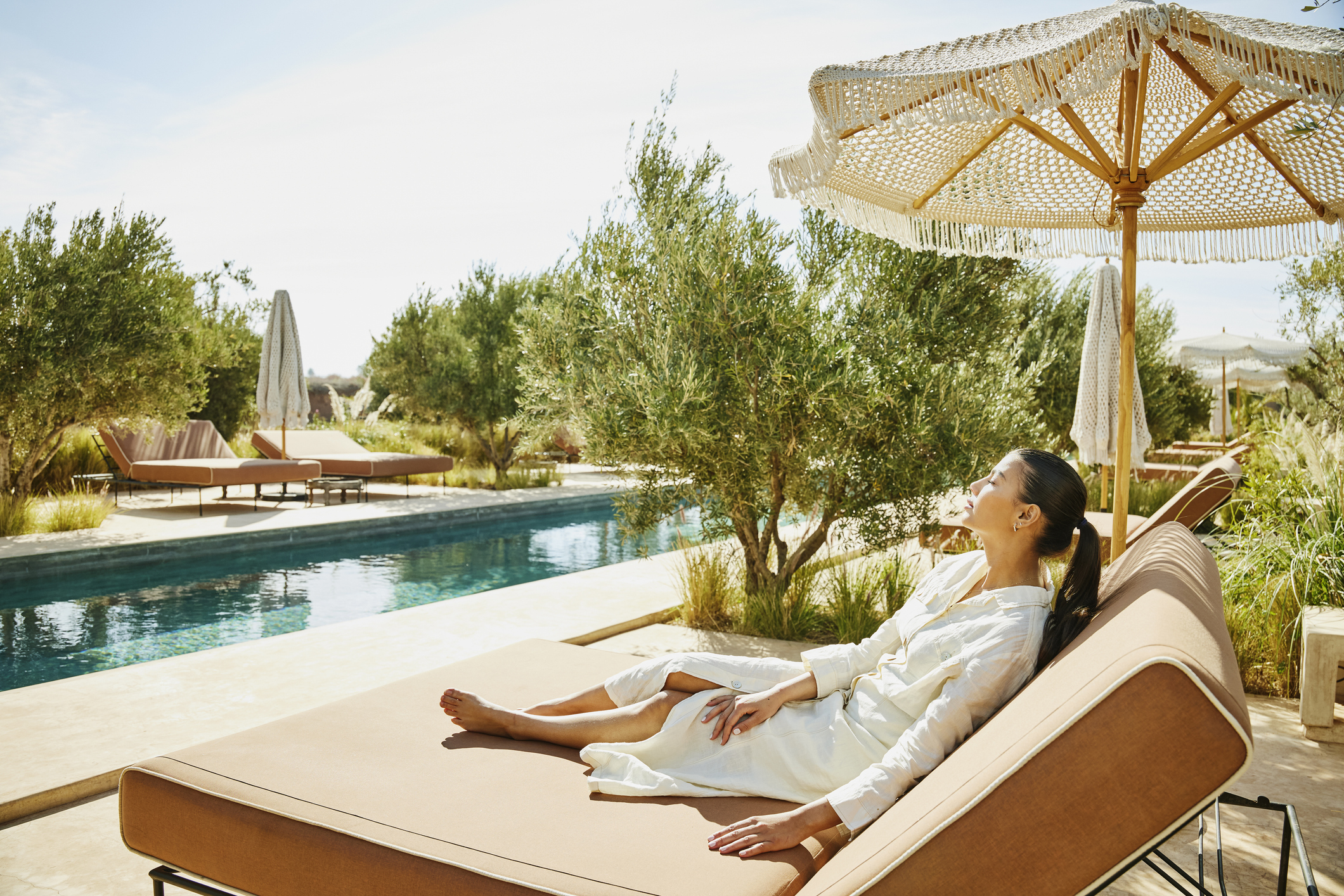 Vrouw geniet van de zon naast het zwembad in Marokko