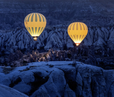 Twee luchtballonnen zweven in het donker boven cappadocie in Turkije