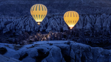 Twee luchtballonnen zweven in het donker boven cappadocie in Turkije