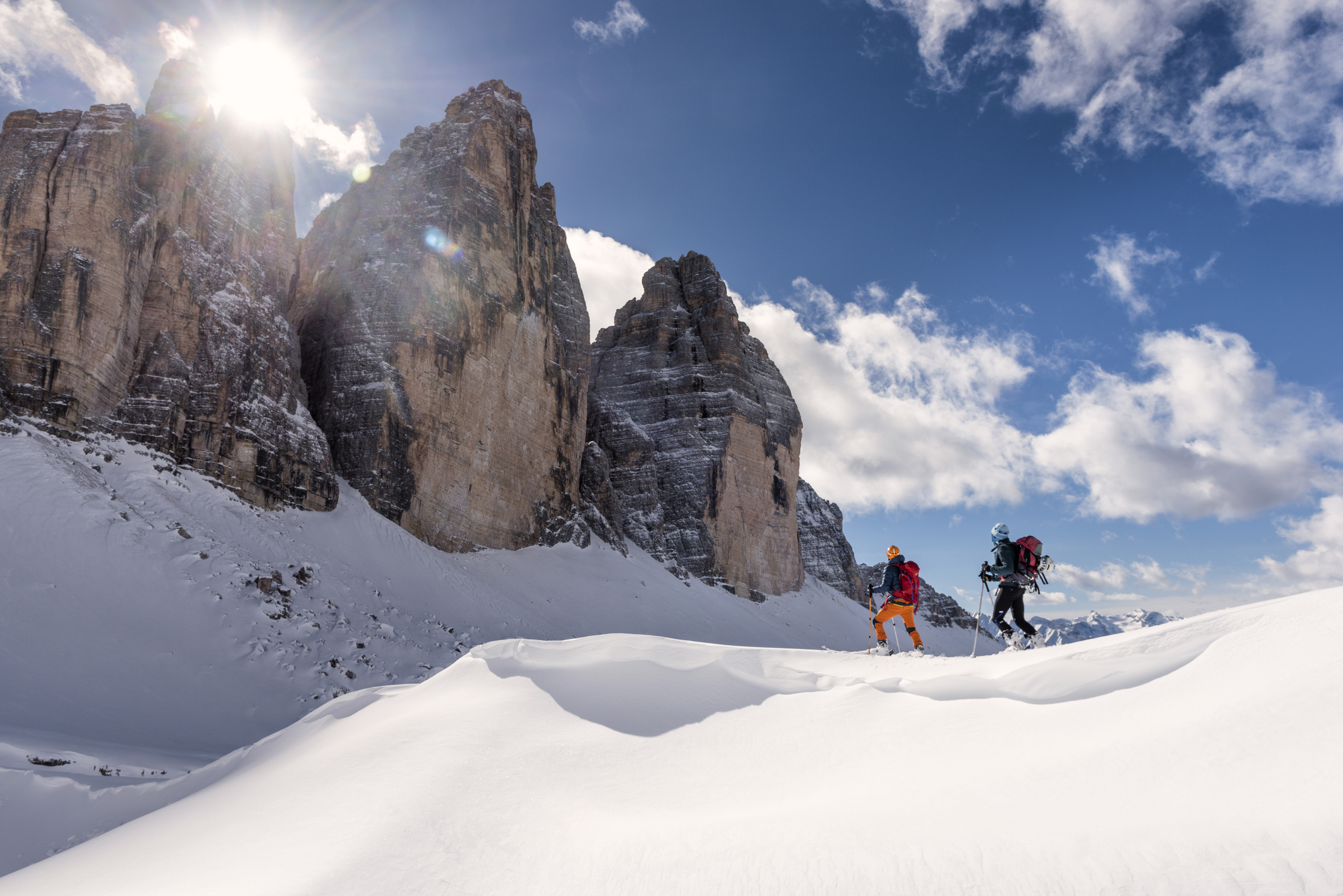 Twee hikers lopen door de sneeuw naar Tre Cime di Lavaredo in de Dolomieten, Italië