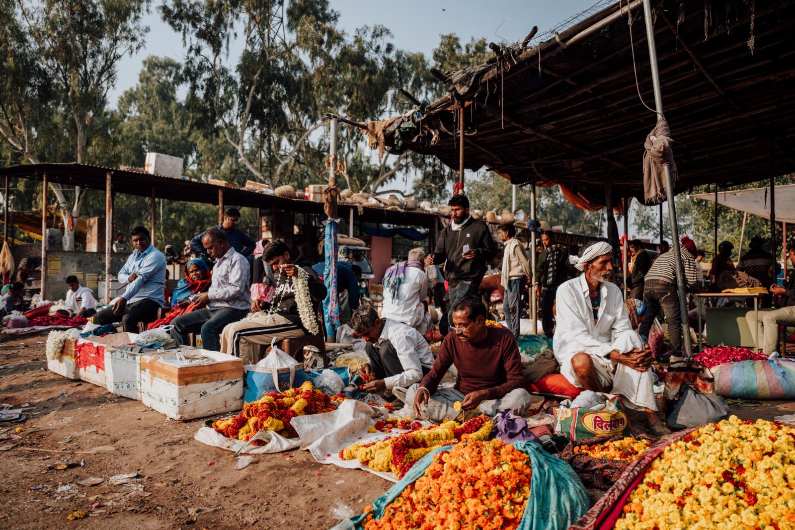 Verkopers met bloemenkransen op de bloemenmarkt van Jaipur in India