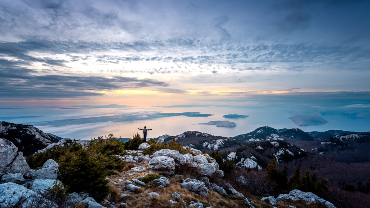 Man staat met armen wijd in Northern Velebit National Park in Kroatie