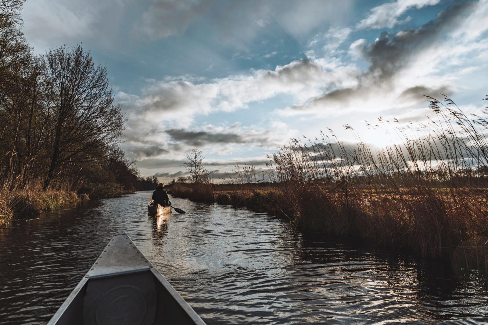 Kano op smalle waterweg door rietlandschap Weerribben-Wieden Overijssel.