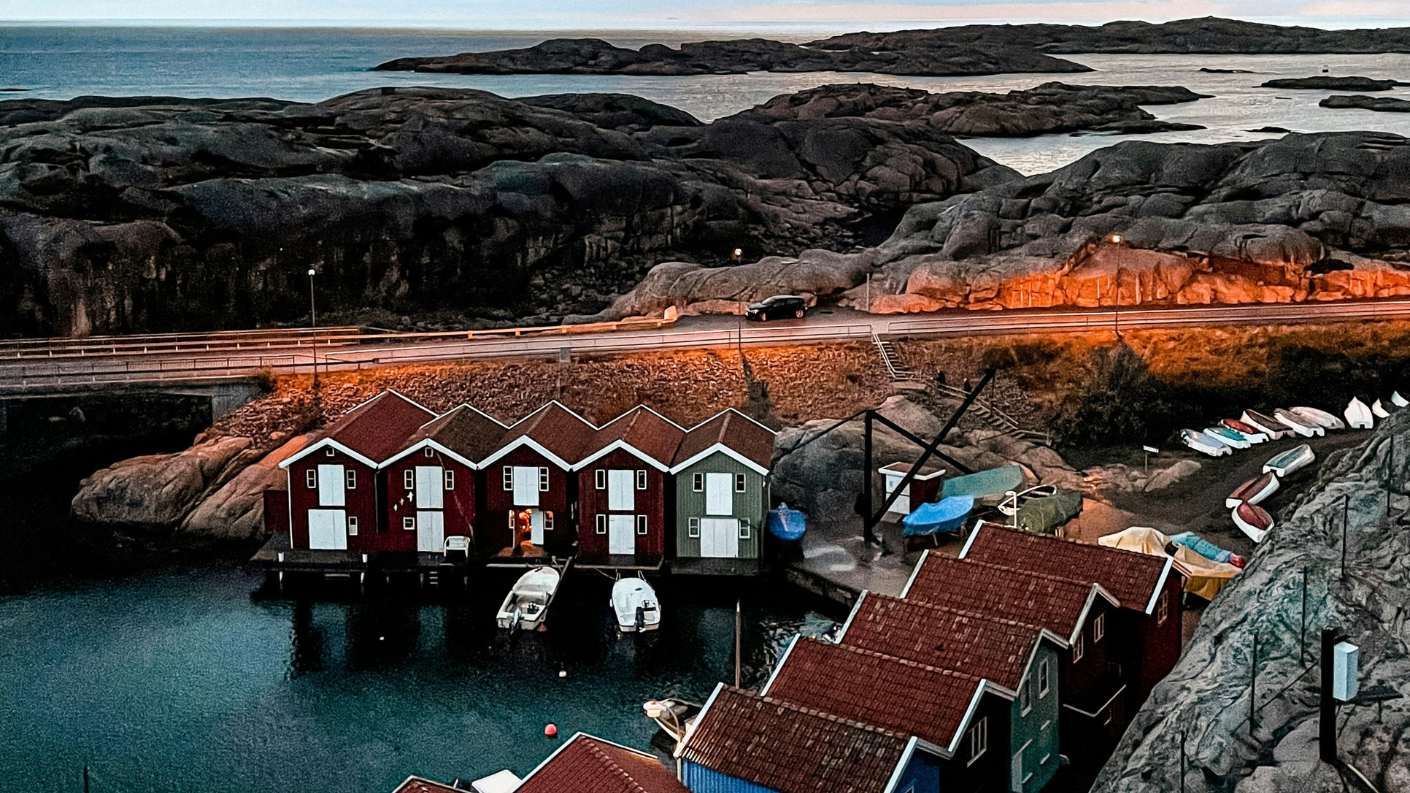 Rijen rode vissershuisjes en boten in een kleine haven aan de rotskust van Bohuslän in Zweden