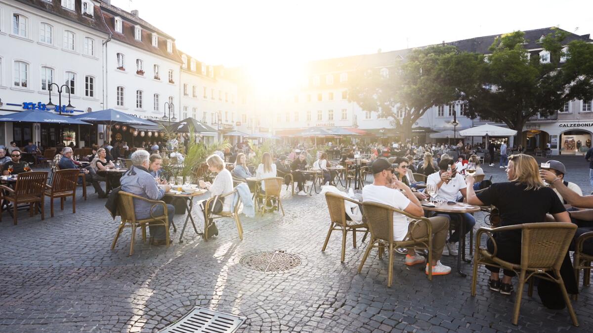 Mensen zitten op terrassen op de St. Johanner Markt in Saarbrücken, Duitsland