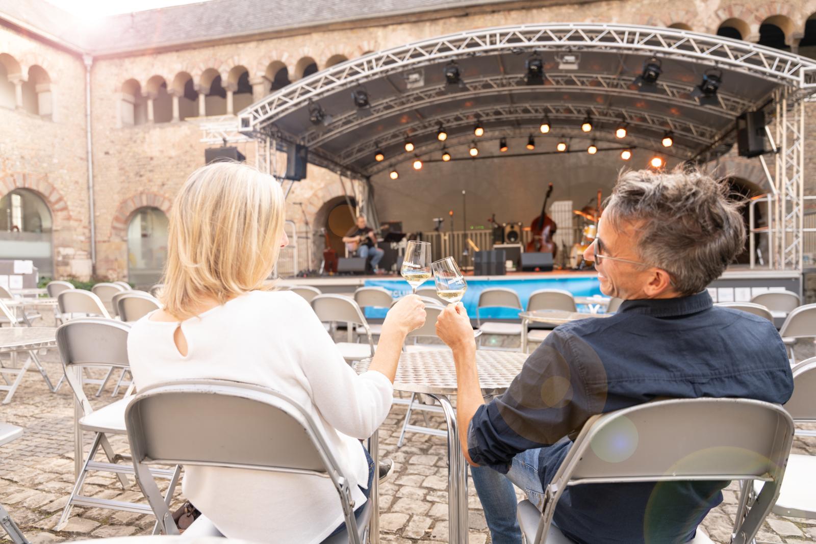 Stel drinkt wijn tijdens een openluchtconcert in de historische Brunnenhof in Trier, Duitsland