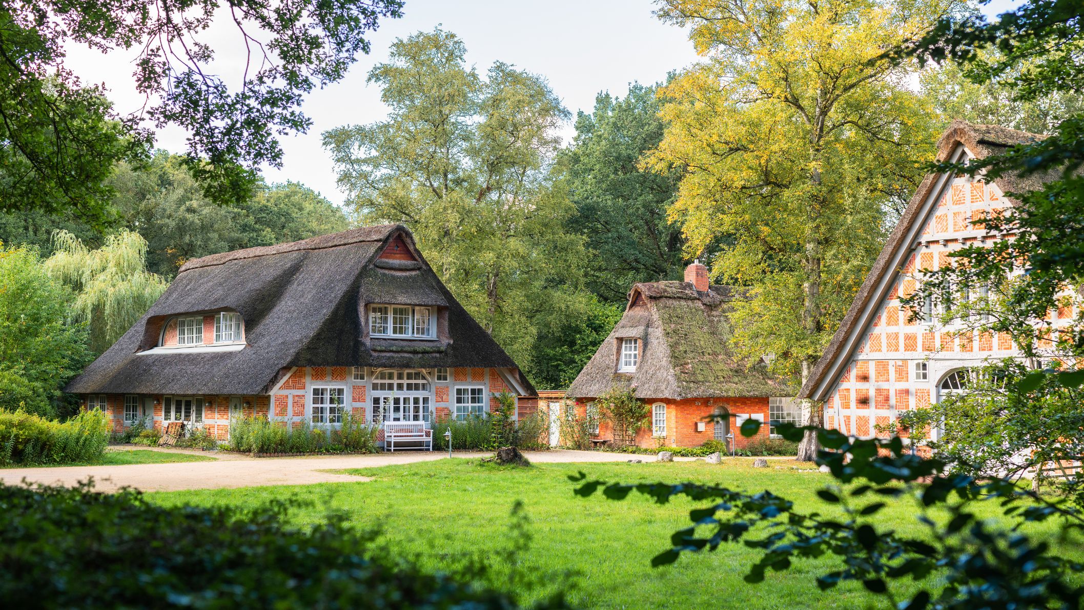 Traditionele Duitse vakwerkhuizen met rieten daken omgeven door groen gras en bomen in het kunstenaarsdorp Worpswede.