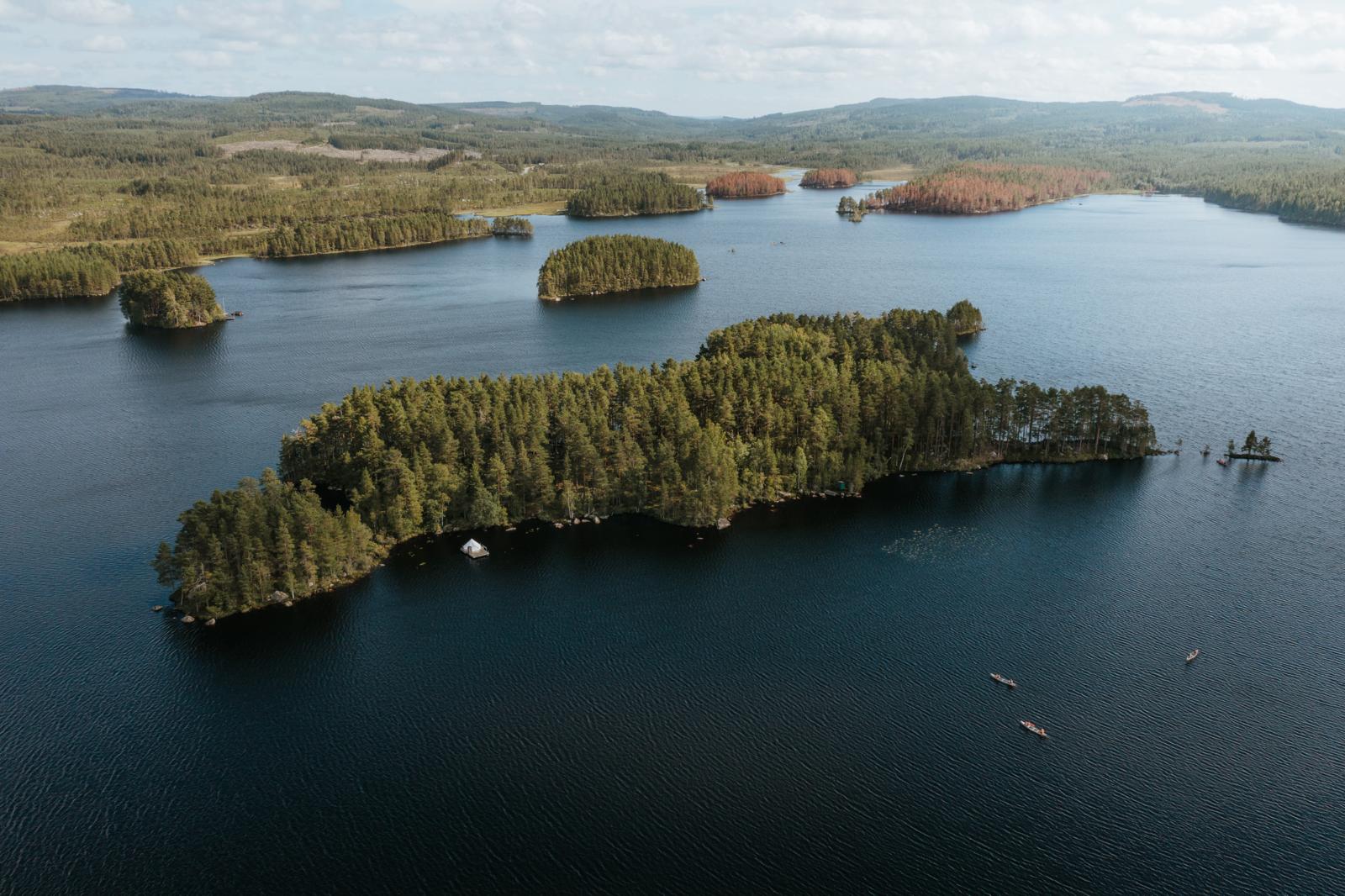 Luchtfoto van beboste eilanden en kanoërs bij Camping Raft Storlom in Värmland