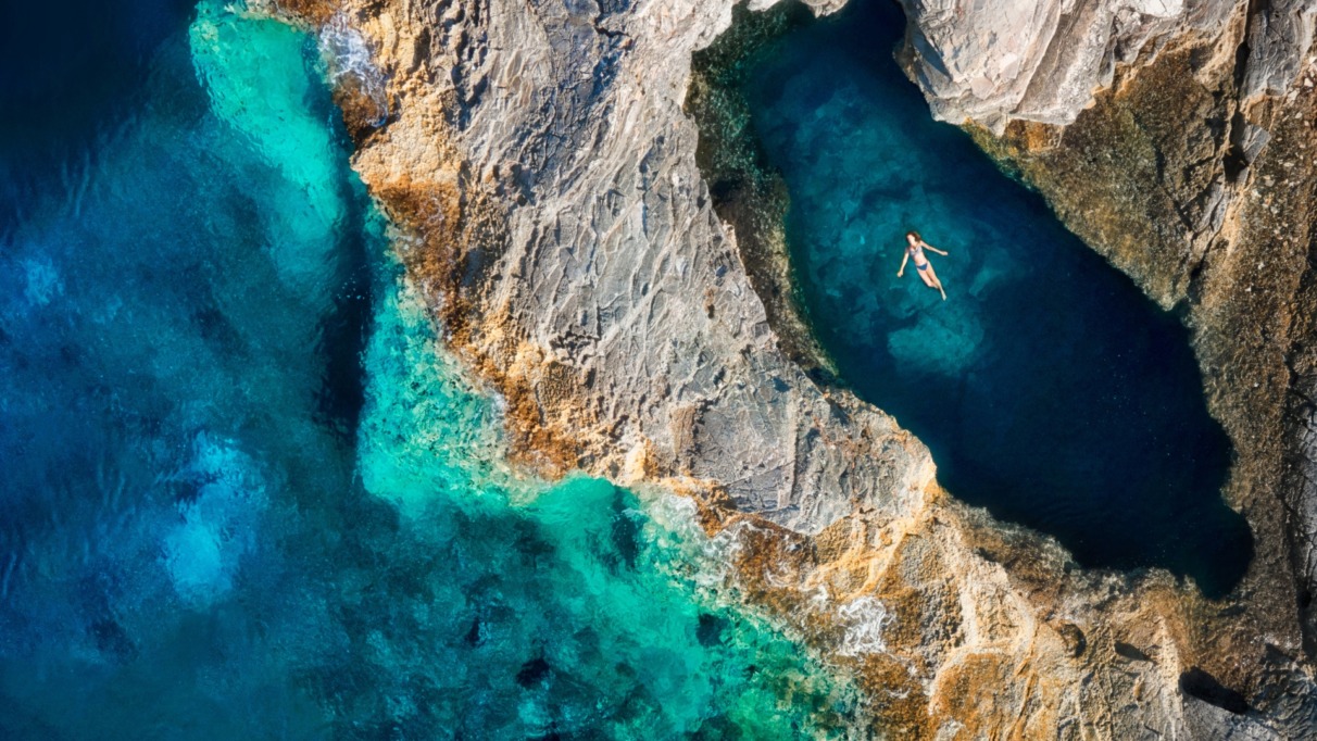 Vrouw drijft in inham of grot van de zee in Kroatië