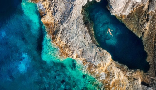 Vrouw drijft in inham of grot van de zee in Kroatië