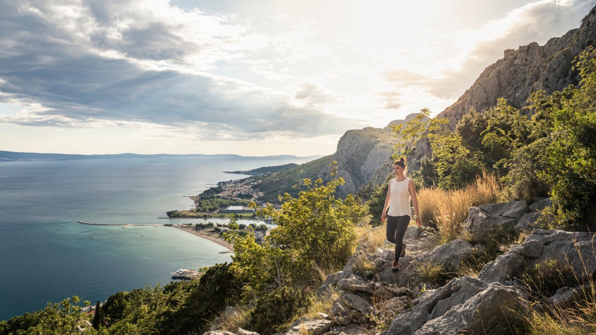 Vrouw wandelt door de bergen met uitzicht over de zee van Kroatië