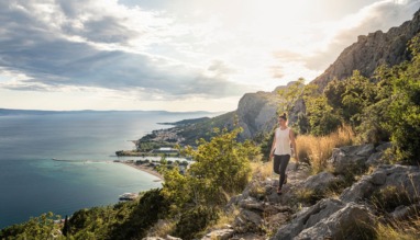 Vrouw wandelt door de bergen met uitzicht over de zee van Kroatië