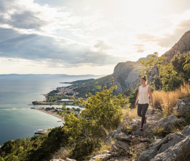 Vrouw wandelt door de bergen met uitzicht over de zee van Kroatië
