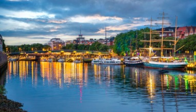 Verlichte kade met historische schepen langs de Weser bij de Schlachte in Bremen bij avond.