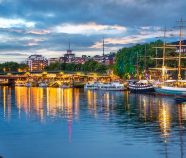 Verlichte kade met historische schepen langs de Weser bij de Schlachte in Bremen bij avond.