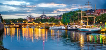 Verlichte kade met historische schepen langs de Weser bij de Schlachte in Bremen bij avond.