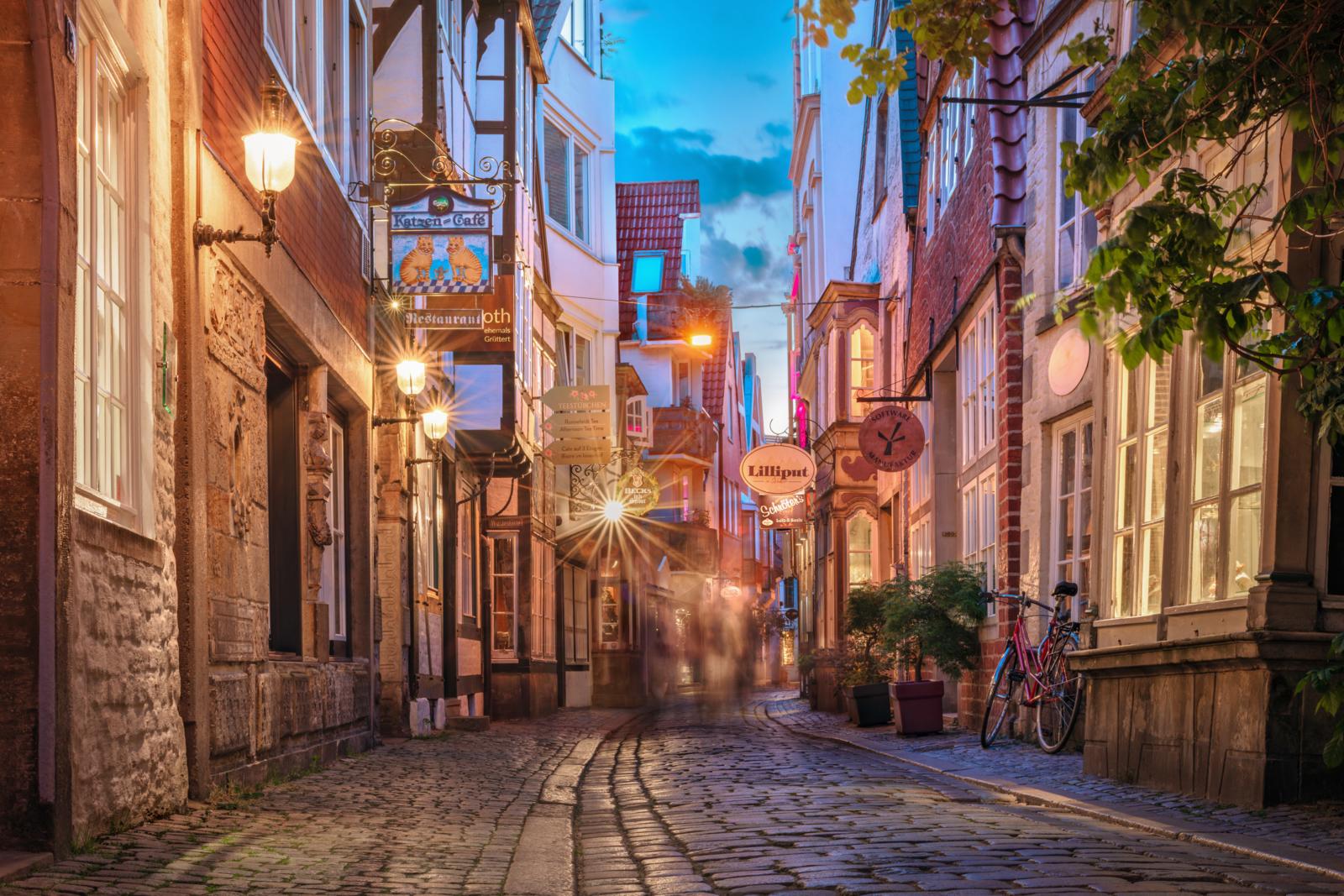 Smalle straat met kinderkopjes en sfeerverlichting in het Schnoorviertel in Bremen.
