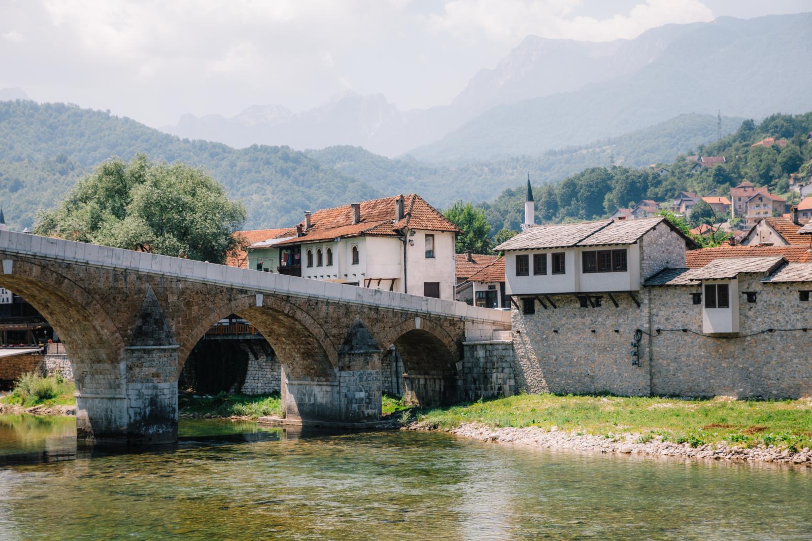 stenen brug van Konjic over de Neretva met huizen en bergen op de achtergrond