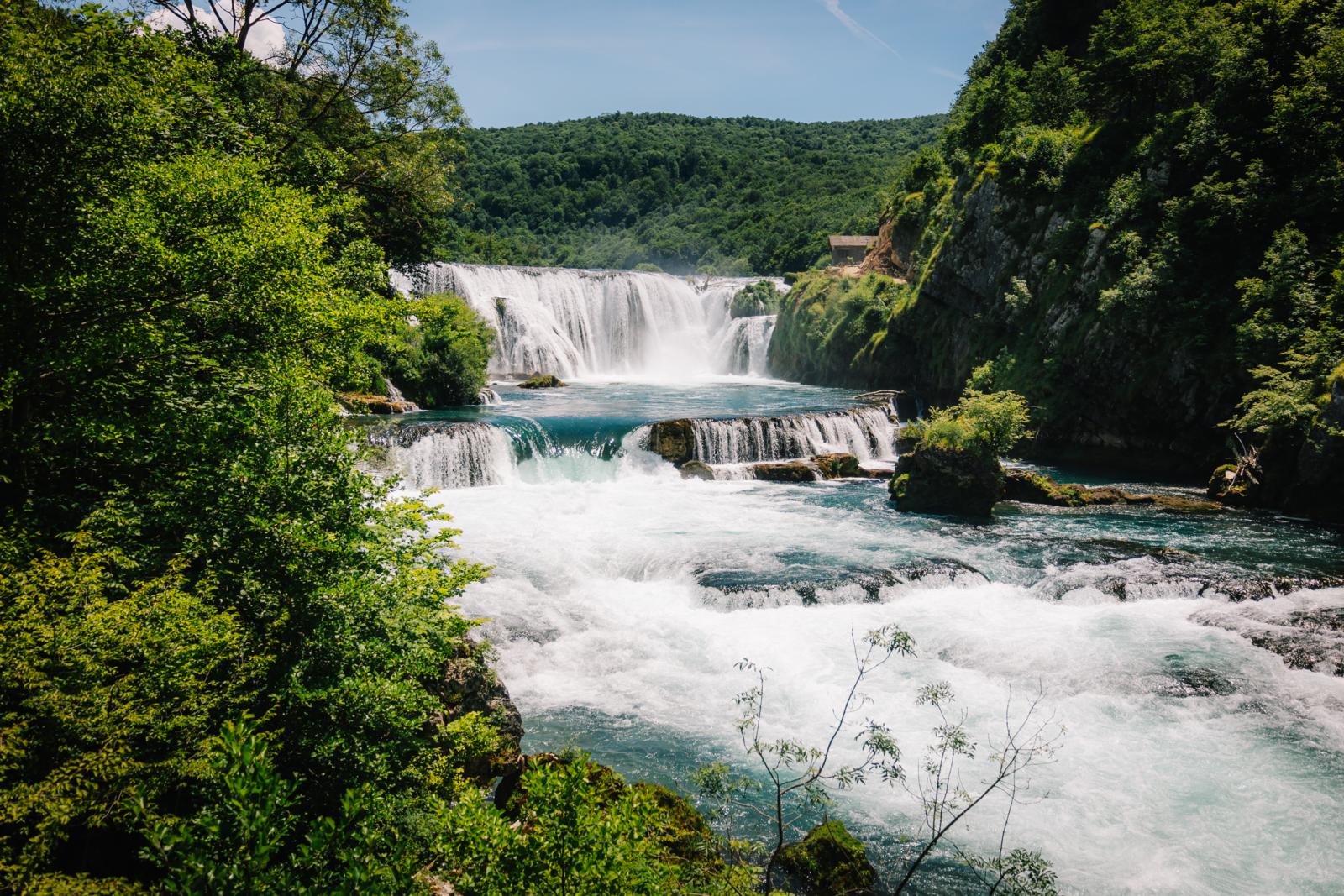 brede watervallen van Kravica in Bosnië en Herzegovina omringd door groen