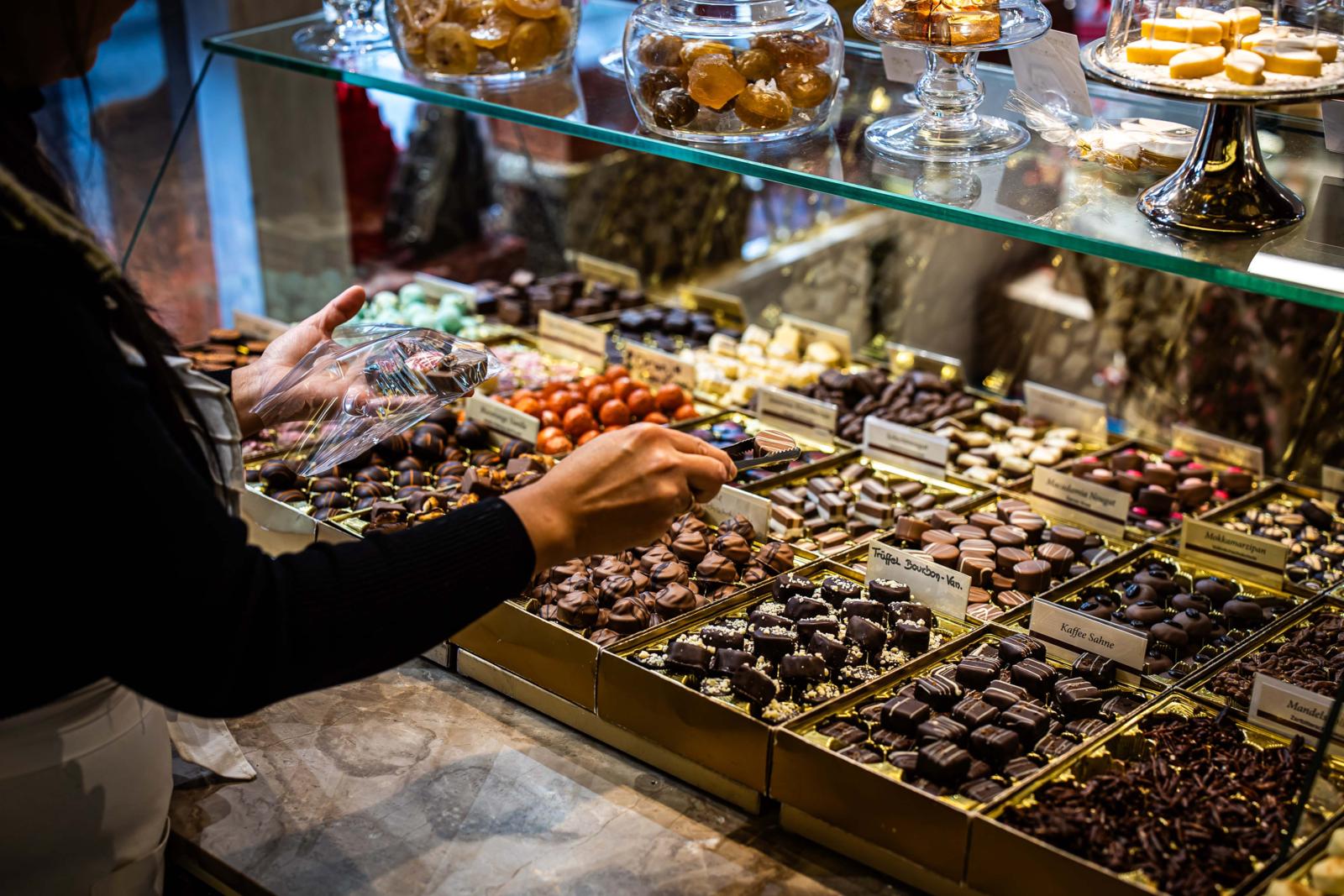 Close-up van een etalage met diverse luxe handgemaakte pralines en bonbons in een winkel in Wiesbaden.