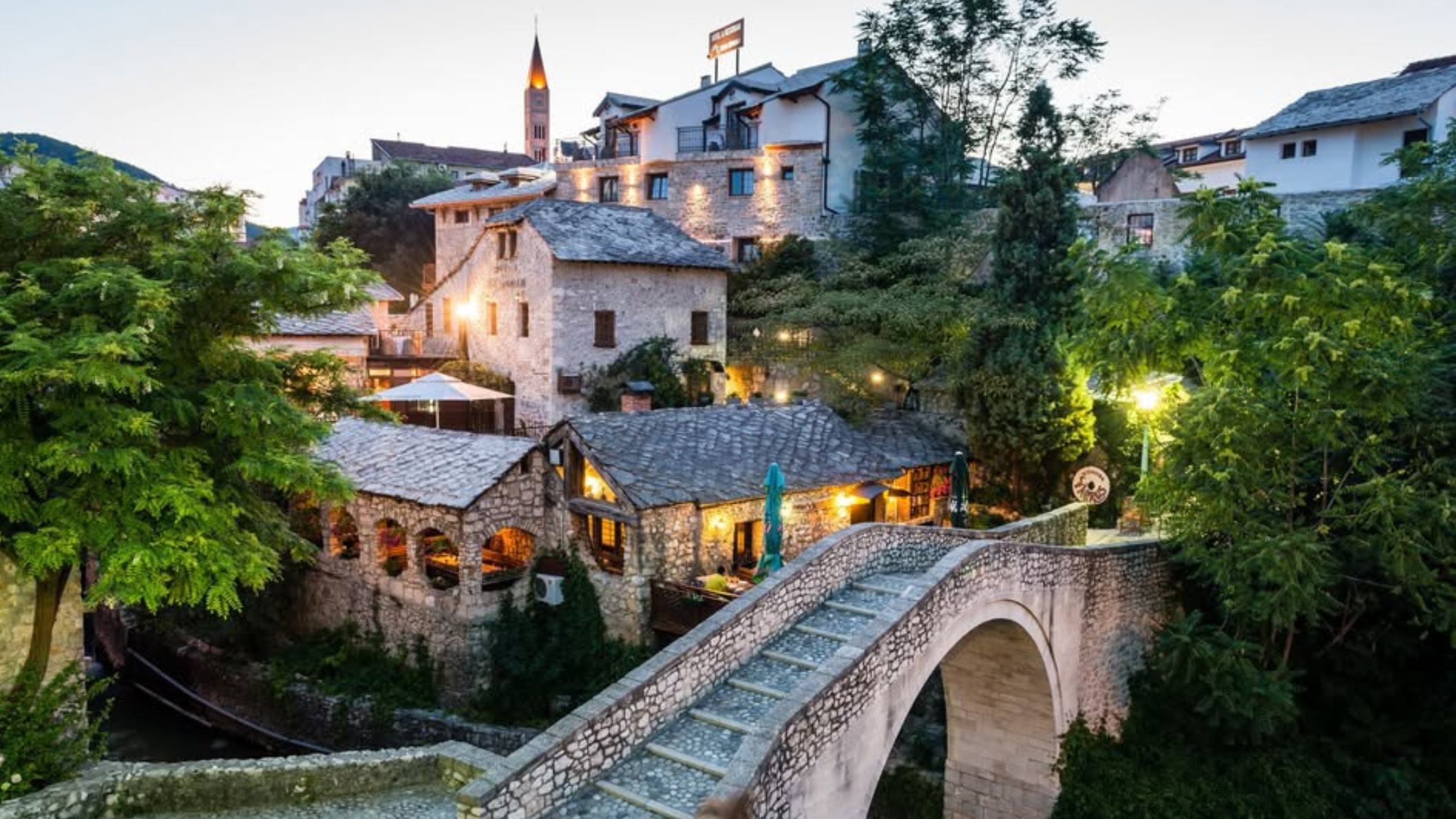 stenen brug en Hotel Kriva Ćuprija in het oude centrum van Mostar bij schemerlicht