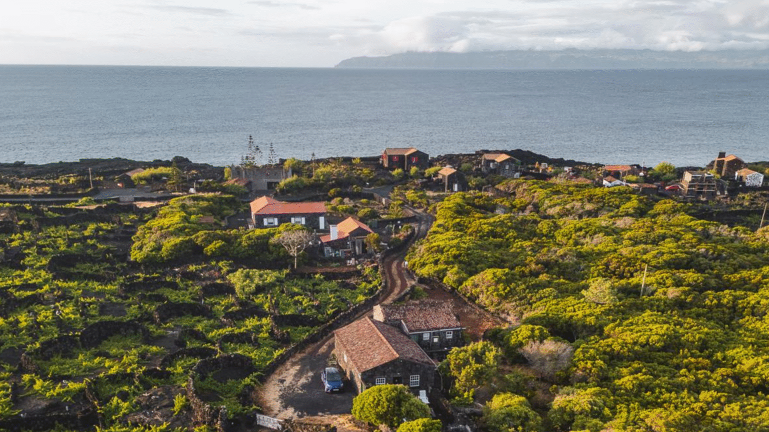 kustdorp en lavalandschap op Pico met uitzicht op de Atlantische oceaan richting Faial, Azoren