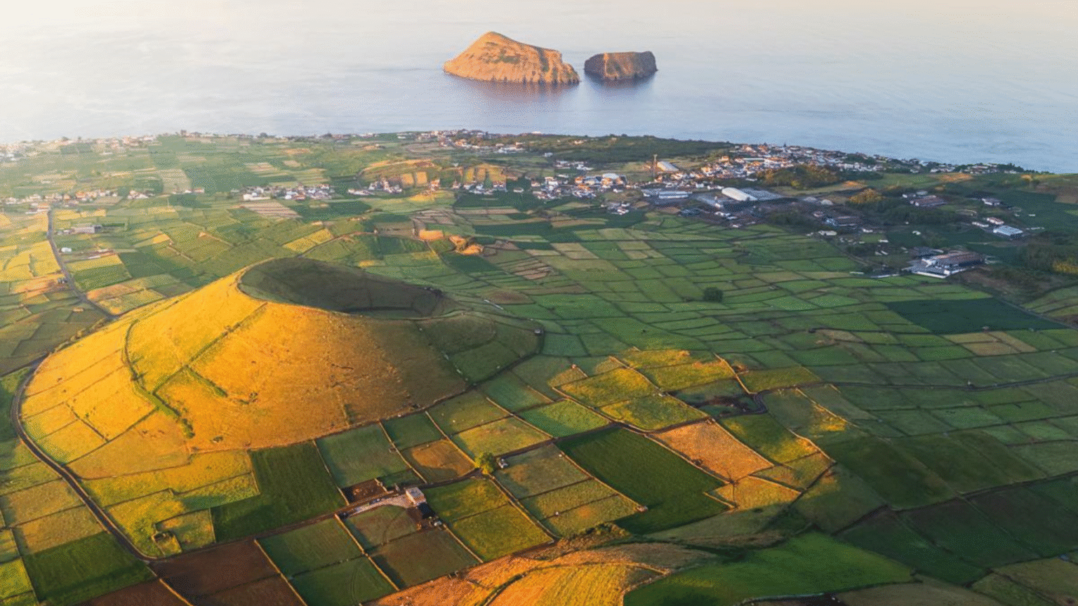 luchtfoto van groene akkers op Terceira met Ilhéus das Cabras in zee, Azoren