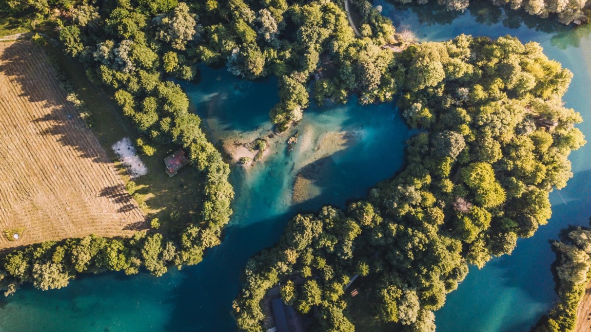 luchtfoto van de kronkelende Una-rivier met turquoise water en beboste oevers in Bosnië en Herzegovina